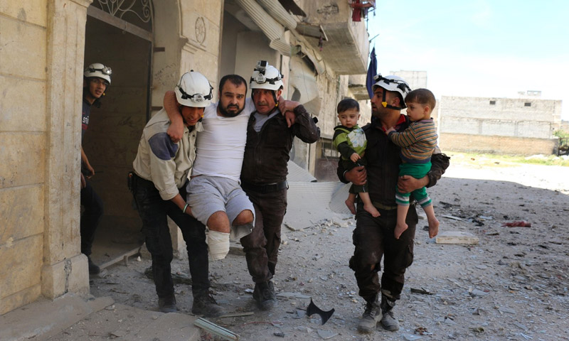عناصر في الدفاع المدني السوري ينقلون عائلة في حي النيرب بحلب 27 نيسان 2016 (أمير الحلبي - AFP)
