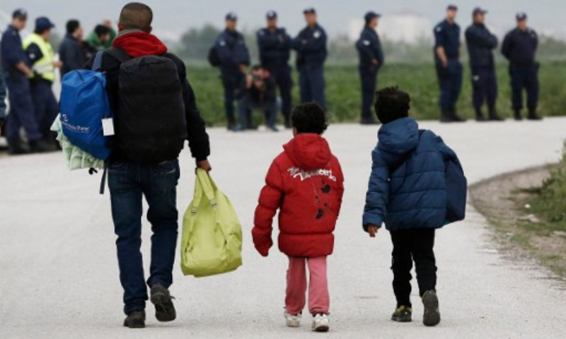 اللاجئون أثناء مغادرتهم مخيم "إيدوميني" في اليونان - الثلاثاء أيار (AFP)