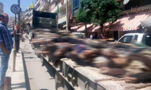شاحنة محملة بجثث 60 قتيلًا من المعارضة في شوارع  مدينة عفرين، 28 نيسان.