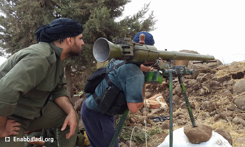 مقاتلو المعارضة أثناء اقتحام قرية الزارة في ريف حماة، الاثنين 16 أيار (عنب بلدي).
