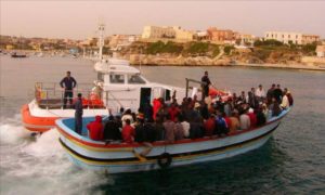 لاجئون قادمون من ليبيا إلى جزيرة لامبيدوزا برفقة خفر السواحل الإيطالي (الجزيرة)
