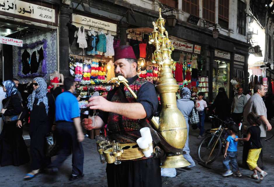 رجل سوري يبيع مشروب التمر الهندي في سوق الحميدية (AFP)