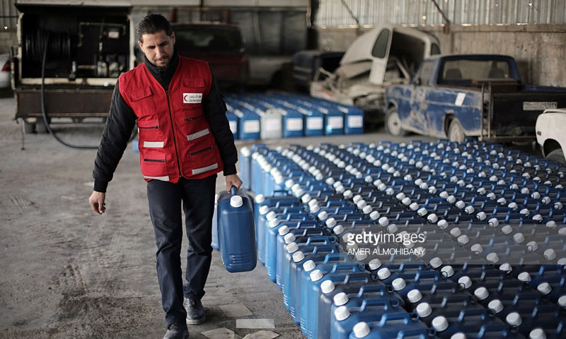 عنصر في الهلال الأحمر القطري ينظم توزيع الوقود في الغوطة الشرقية لدمشق - آذار 2016 (AFP)