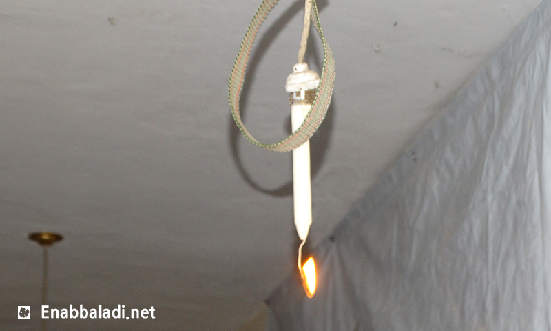 إضاءة المعرض بالشموع لانقطاع الكهرباء المستمر في حي الوعر- الثلاثاء 21 حزيران (عنب بلدي)
