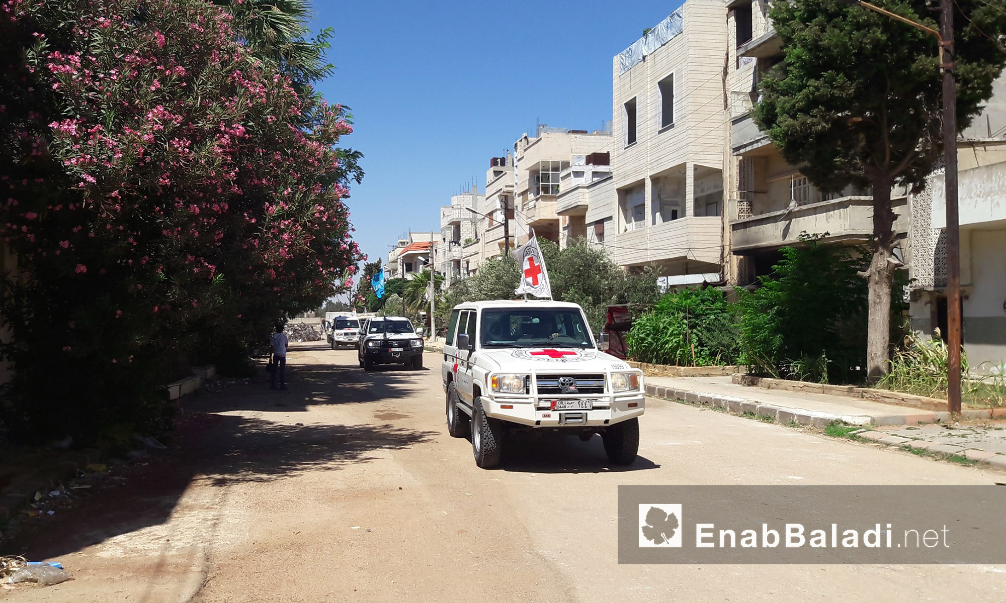 سيارات الوفد المرافق لقافلة  المساعدات داخل حي الوعر في حمص - الخميس 14 تموز (عنب بلدي)