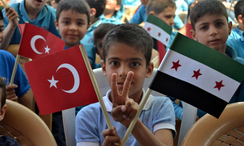 طفل سوري يرفع علما تركيا والثورة السورية (انترنت)