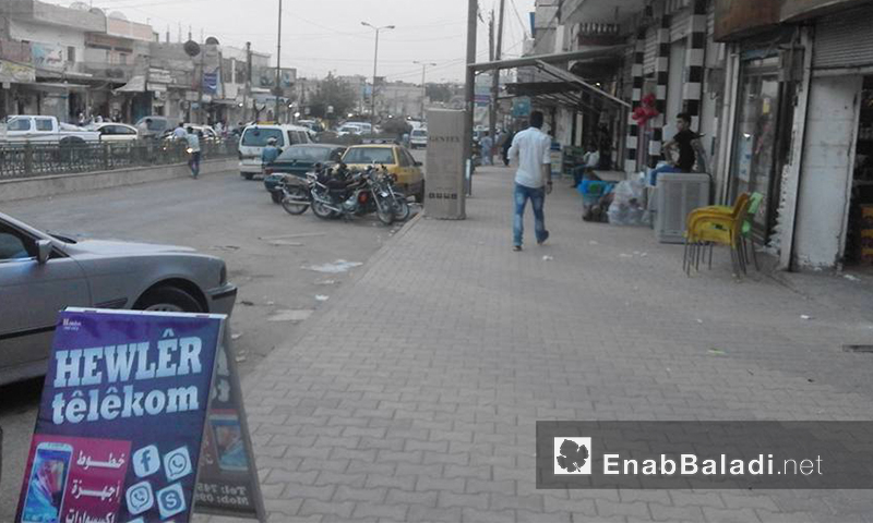لائحة إعلانات أسعار وخطوط اتصالات على أرصفة أحد شوارع القامشلي (عنب بلدي)