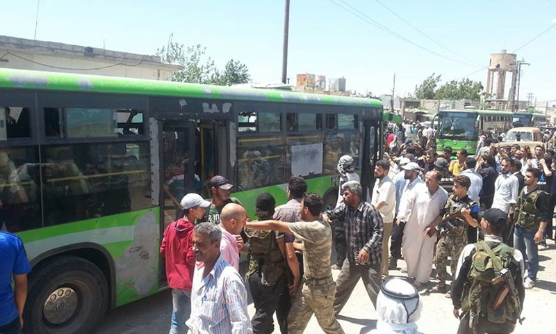 مقاتلو وأهالي قزحل قرب حافلات نقلهم إلى ريف حمص الشمالي - السبت 16 تموز (ناشطون)