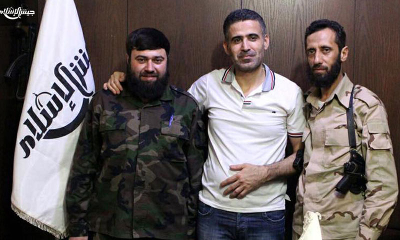 الشاب أيمن المدني في الوسط إلى جانب عصام بويضاني قائد "جيش الإسلام" (فيس بوك)