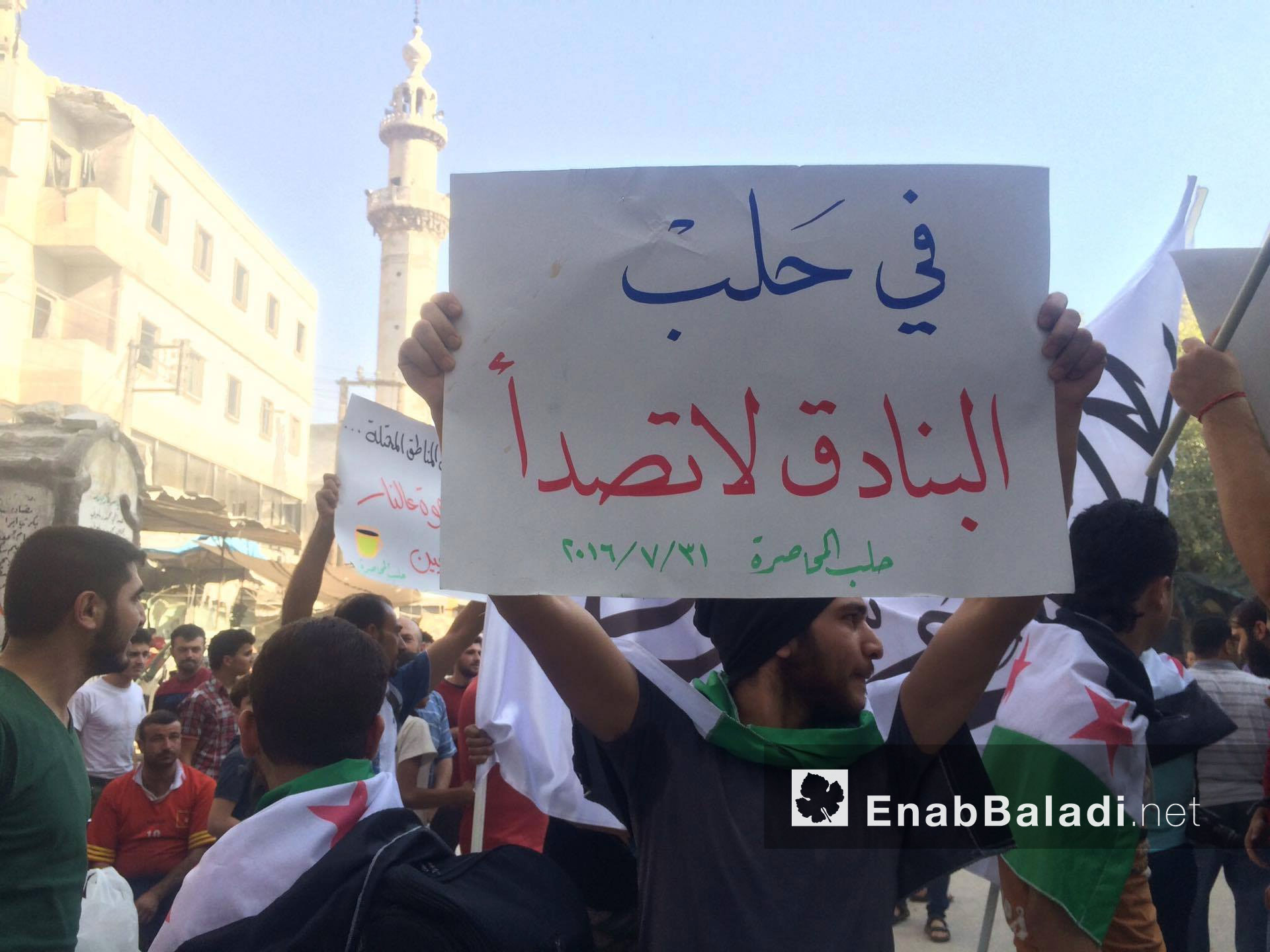 مواطن يحمل لافتةً تنادي بالاستمرار في القتال في مدينة حلب - 31 تموز 2016 (عنب بلدي)