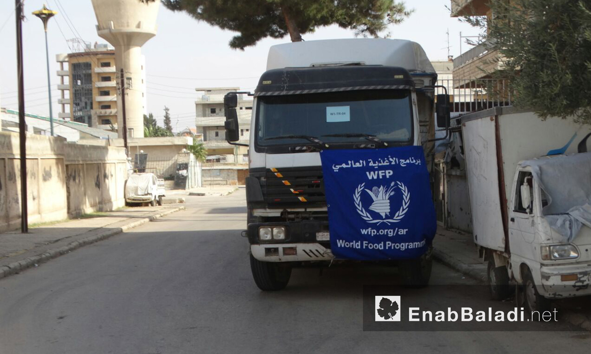 سيارات برنامج الأغذية العالمي داخل حي الوعر المحاصر في حمص - الثلاثاء 23 آب (عنب بلدي)