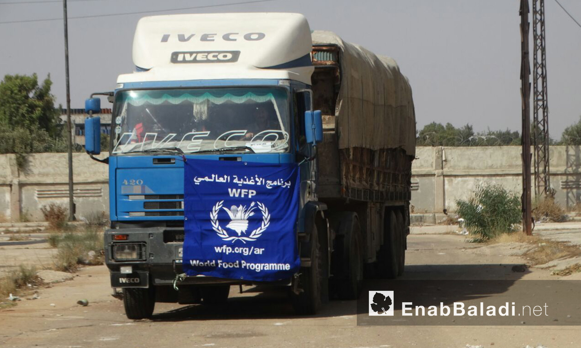 سيارات برنامج الأغذية العالمي داخل حي الوعر المحاصر في حمص - الثلاثاء 23 آب (عنب بلدي)