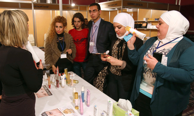 سيدات سوريات يتفحصن منتجات للتجميل في أول معرض متخصص في دمشق 7 كانون الأول 2014 (AFP)
