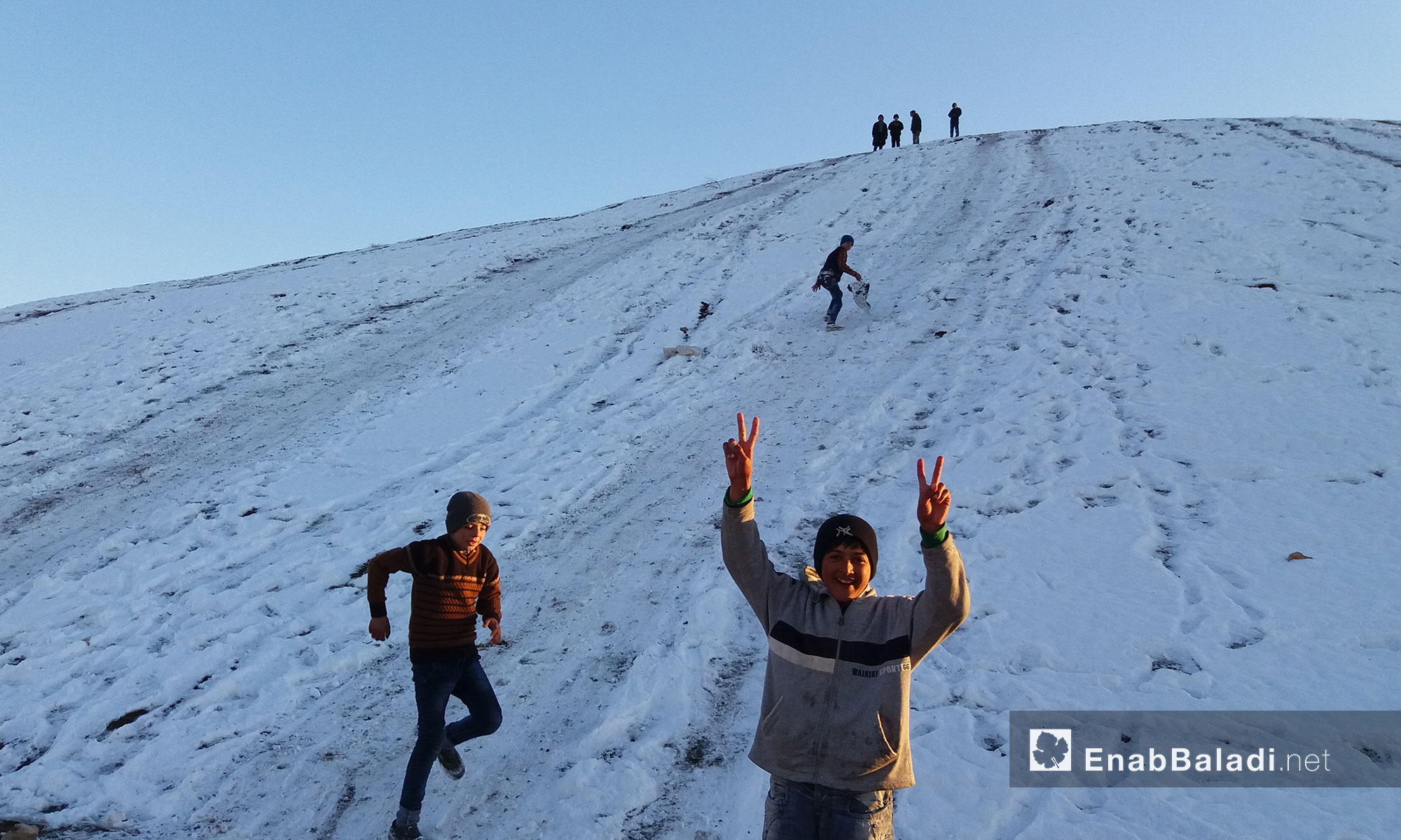 أطفال يستمتعون بالتزلج على تلة دابق بعد تساقط الثلوج - 29 كانون الثاني 2017 (عنب بلدي)
