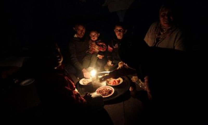 عائلة من اللاذقية تتناول طعامها على ضوء الشموع (فيس بوك)