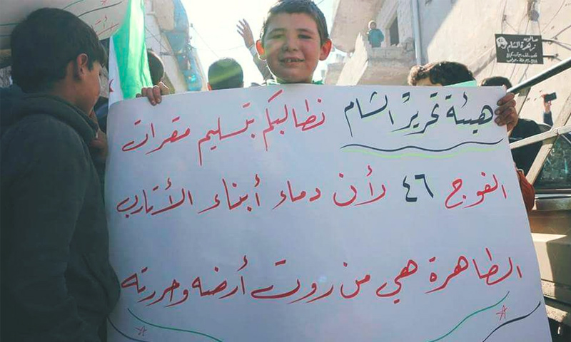 طفل يحمل لافتة في مظاهرة ضد "هيئة تحرير الشام" في الأتاريف غرب حلب - 3 شباط 2017 (فيس بوك)
