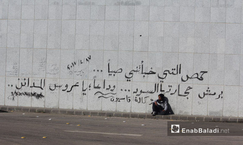 عبارة كتبها مهجرو الوعر على جدارٍ في الحي قبل خروجهم إلى جرابلس- 24 نيسان 2017 (عنب بلدي)