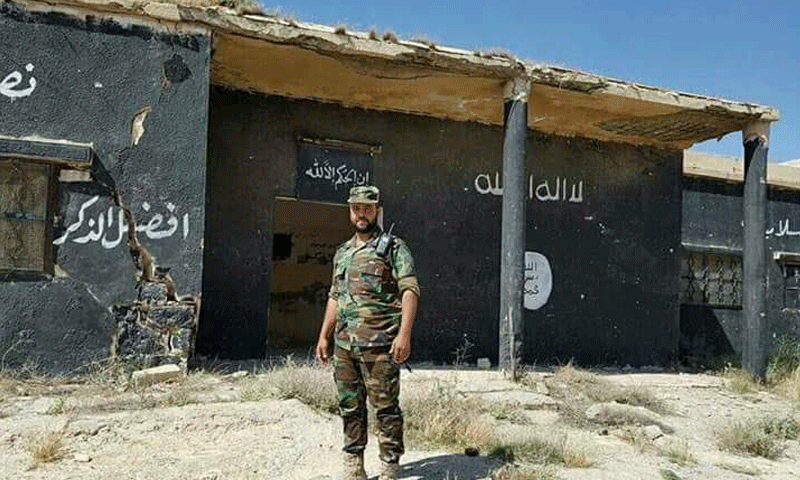 عنصر من قوات الأسد أمام مقر لتنظيم الدولة في ريف حلب الشرقي - (فيس بوك)