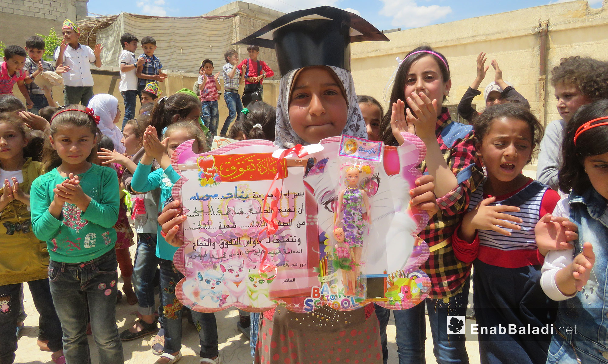 طفلة تحمل شهادة تفوق خلال حفلٍ للمتفوقين  في صوران شمال حلب - 25 أيار 2017 (عنب بلدي)