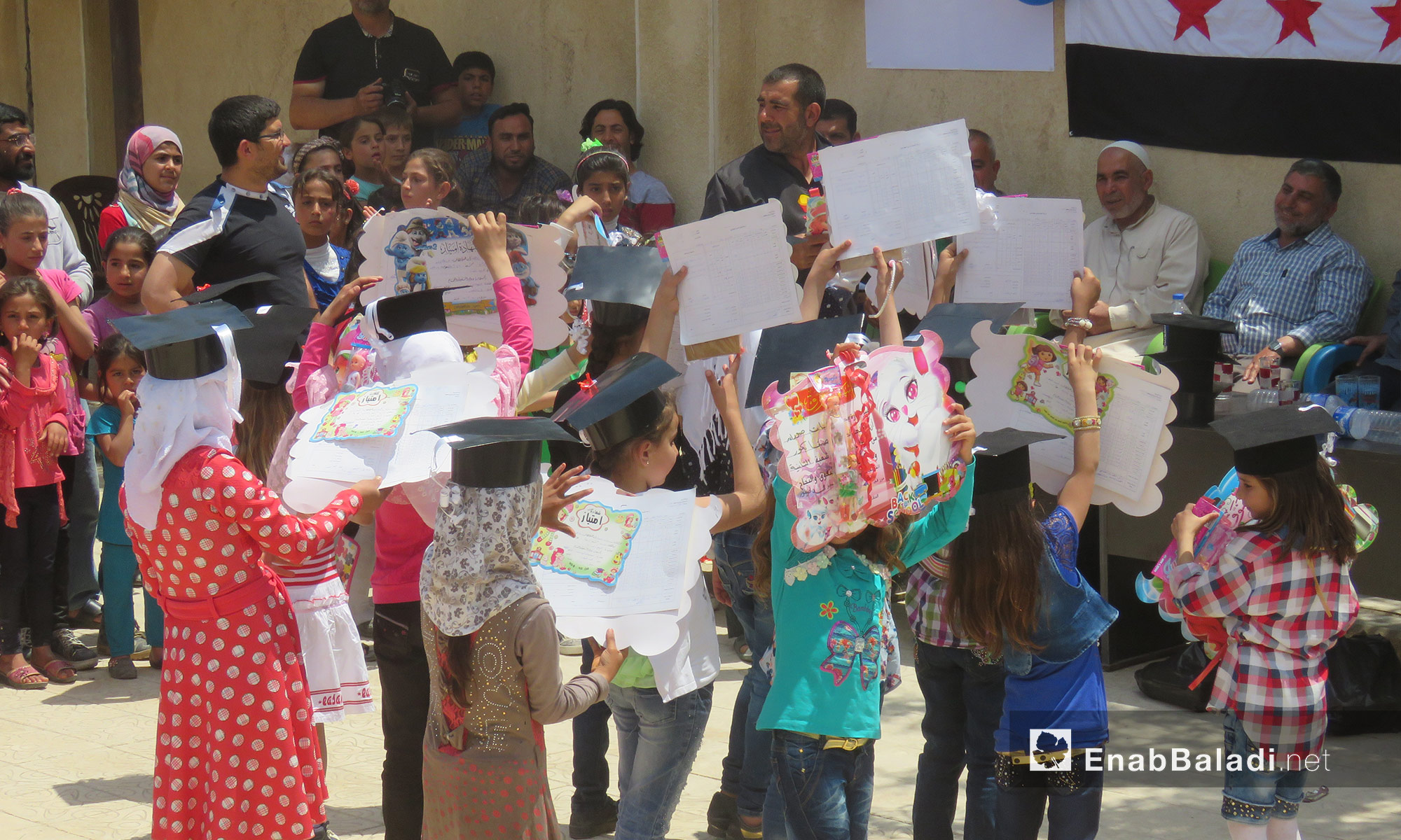 أطفال يحملون شهاداتهم خلال حفلٍ للمتفوقين  في صوران شمال حلب - 25 أيار 2017 (عنب بلدي)