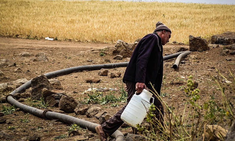 مسن ينقل المياه من وادي قرية حيط بحوض اليرموك في ريف درعا الغربي - 1 أيار 2017 -(مؤسسة نبأ)
