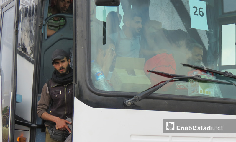 مقاتل من المعارضة داخل حافلة تقل مهجري الوعر إلى جرابلس شمال حلب - 5 أيار 2017 (عنب بلدي)