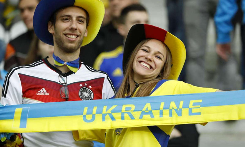 تعبيرية لمشجعة أوكرانية إلى جانب مشجع للمنتخب الألماني (رويترز)
