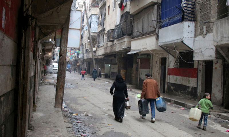 مواطنون في مدينة حلب يحملون عبوات لملئها بالماء (AP)
