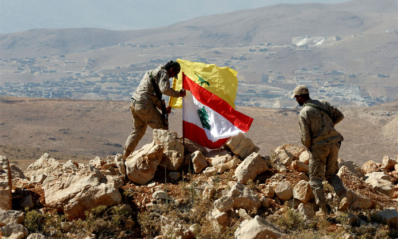 مقاتلون يضعون العلم اللبناني إلى جانب علم حزب الله في جرود عرسال 25 تموز 2017 ( رويترز)