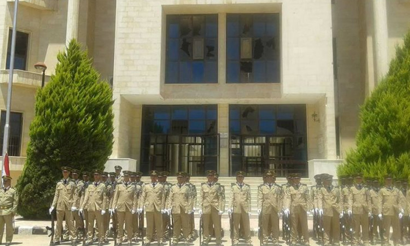 عناصر من الشرطة التابعة للنظام السوري أمام قصر العدل في حي الوعر في مدينة حمص - (انترنت)