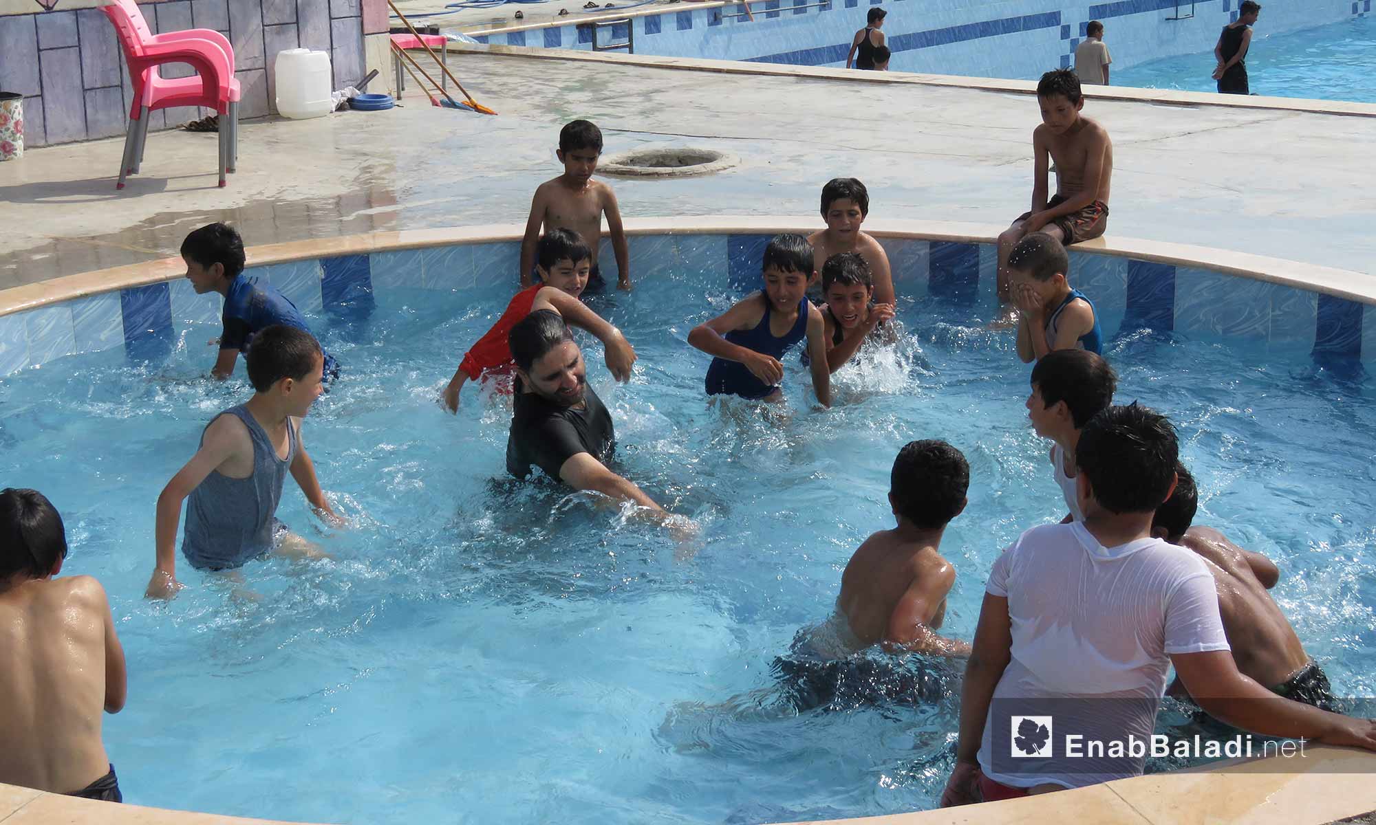 طلاب مع مدرب السباحة في أحد مسابح ريف حماة الغربي - 22 آب 2017 (عنب بلدي)