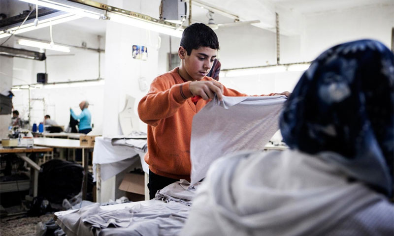يافع سوري يعمل في مشغل خياطة (NARPHOTOS)
