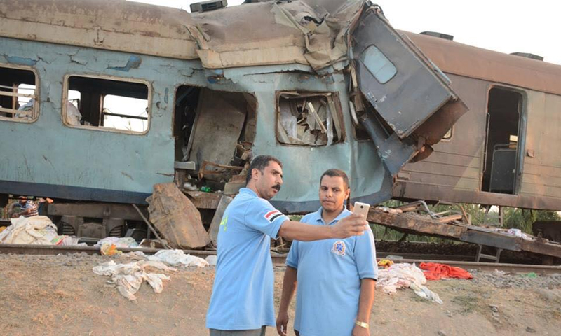 مسعفان يلتقطان "سيلفي" أمام حادث تصادم قطارين في الاسكندرية - الجمعة 11 آب - (انترنت)