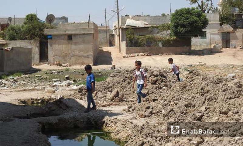 أطفال قرب شبكة للصرف الصحي في بلدة دابق في ريف حلب الشمالي - 1 أيلول 2017 (عنب بلدي)