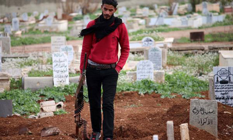 مقاتل من المعارضة السورية في مقبرة بريف درعا الجنوبي - 20 آذار 2017 (AFP)

