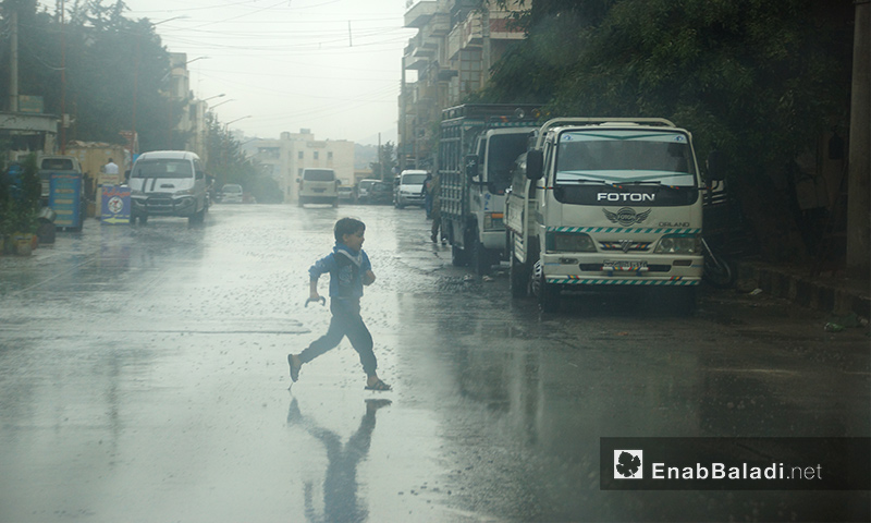 طفل يركض تحت المطر في مدينة إدلب - 9 تشرين الأول 2017 (عنب بلدي)