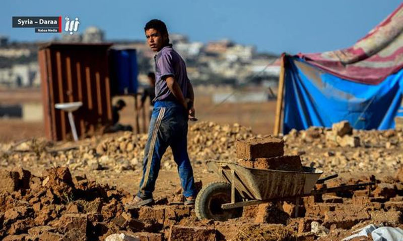 شاب يقوم بصناعة قطع اللبن المستخدمة في بناء البيوت الطينية - مخيمات مدينة درعا - (نبأ)

