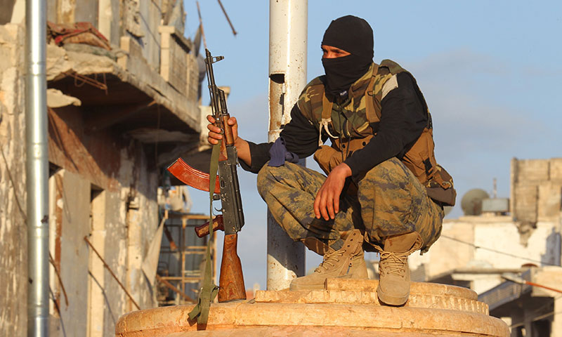 عنصر من هيئة تحرير الشام في مدينة أريحا بريف إدلب بعد السيطرة عليها - أيار 2015 (رويترز)
