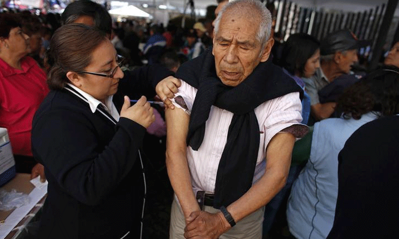 مسن يتلقى تطعيمًا ضد الإنفلونزا الموسمية في المكسيك (رويترز)