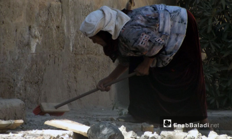امرأة تكنس محيط منزلها المدمر في دير الزور - 2013 (عنب بلدي)