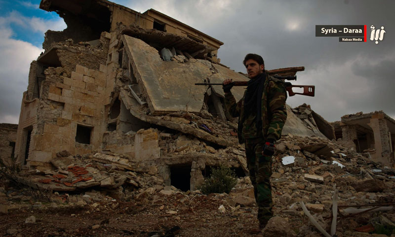 أحد مقاتلي الجيش الحر يقف بجانب الدمار بالقسم الشرقي من مدينة درعا بالقرب من فرع المخابرات الجوية- 31 كانون الثاني (نبأ)
