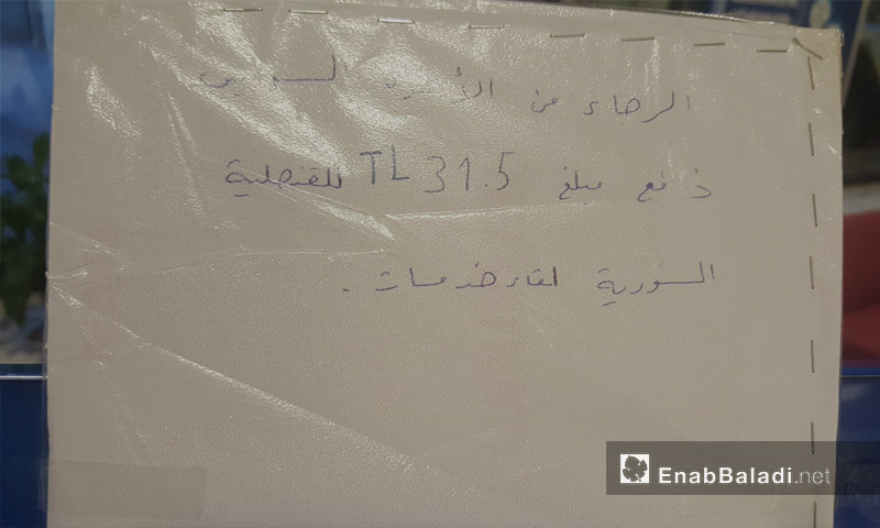 ورقة ملصقة داخل "IC bank" تتضمن طلب دفع 31.5 ليرة تركية من السوريين لقاء خدمات - 20 آذار 2018 (عنب بلدي)