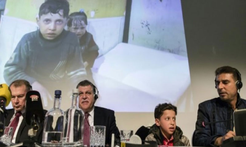 السفير الروسي لدى هولندا الكسندر شولغين (يسار) وإلى جانبه نائب ممثل سوريا لدى منظمة حظر الاسلحة الكيماوية غسان عبيد وصبي ورجل سوريين في مؤتمر صحفي عقد في لاهاي - 26 نيسان 2018 (AFP)