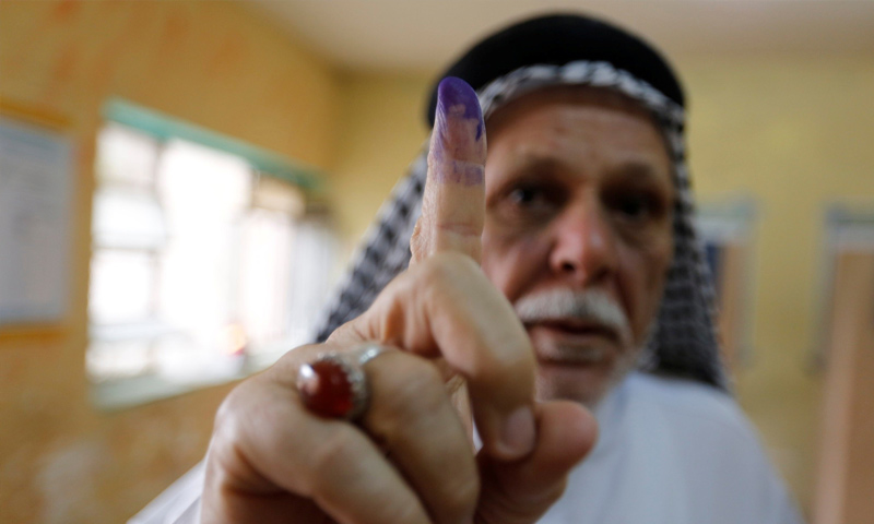 رجل عراقي يظهر اصبعه الملطخ بالحبر بعد الإدلاء بصوته في مركز اقتراع خلال الانتخابات البرلمانية في الصدر - 12 من أيار 2018 (رويترز)