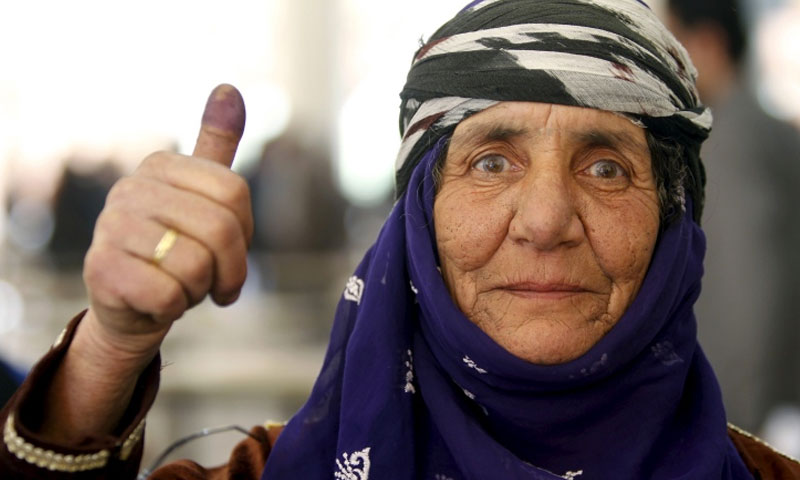 امرأة ترفع إبهامها بعد البصم على انتخابات مجلس الشعب في دمشق (رويترز)