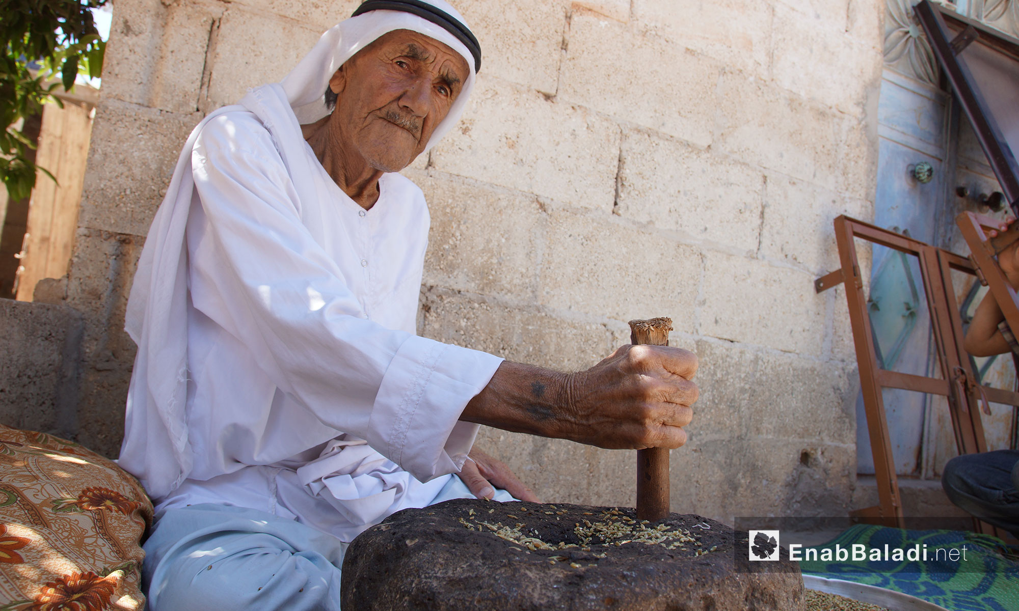 الحاج عبد الغني سليمان يستخدم حجر الرحى في طحن الحبوب في ريف إدلب - 23 حزيران 2018 (عنب بلدي)