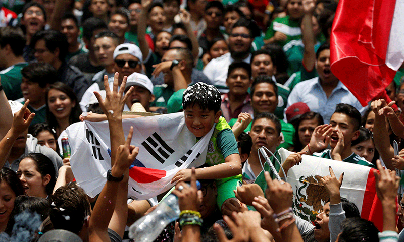 جماهير مكسيكيون يحتفلون أمام السفارة الكورية في بلادهم (رويترز)