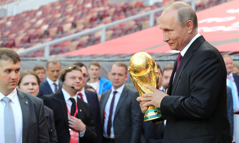 الرئيس الروسي فلاديمير بوتين يحمل كأس العالم (AFP)
