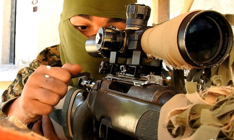 مقاتل من تنظيم الدولة الإسلامية يتفقد سلاحه في محيط مدينة البوكمال - 1 من حزيران - (أعماق)