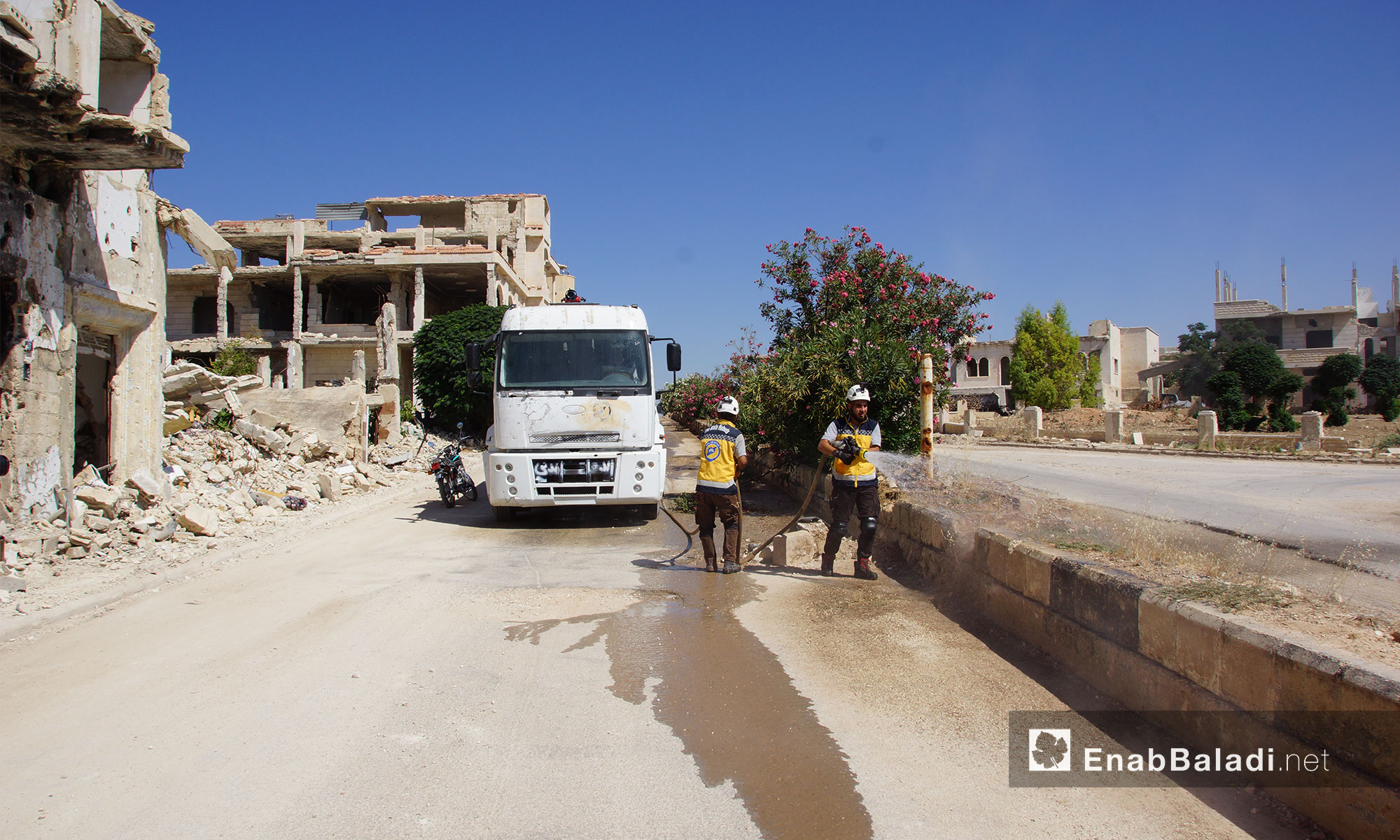 عناصر من الدفاع المدني يقومون بعملية تنظيف للطرقات ضمن حملة "إحياء الأرض" في مدينة مورك بريف حماة - 7 تموز 2018 (عنب بلدي)